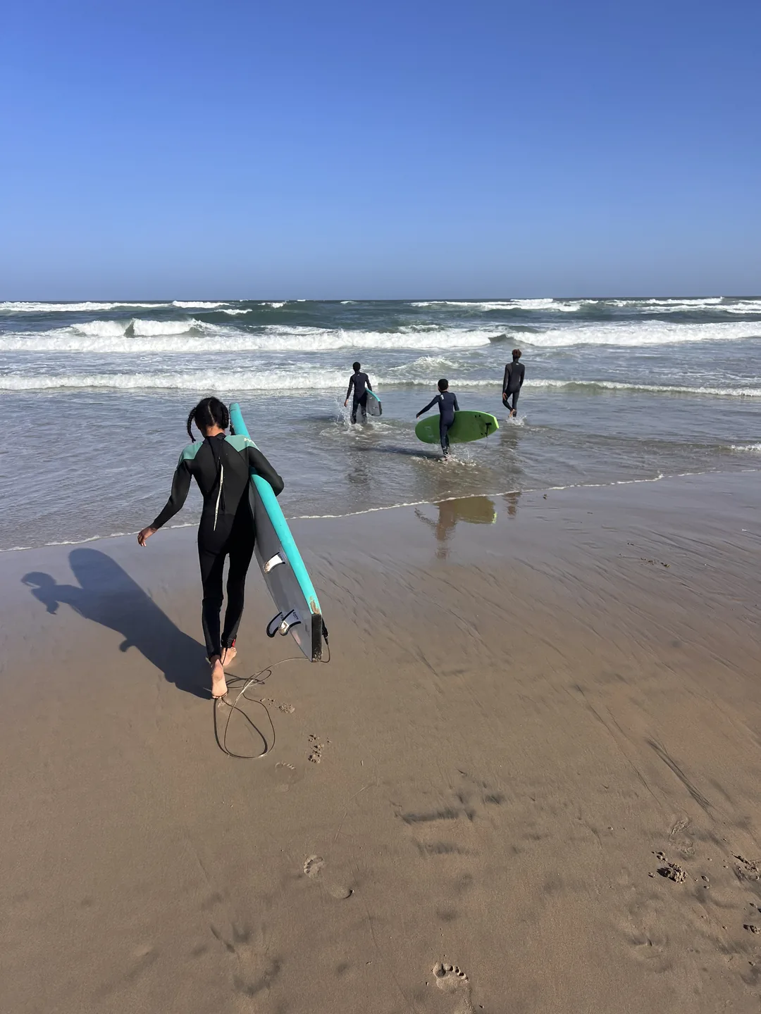 Un groupe de surfeurs se prépare à affronter les vagues sur la plage de Ngor.