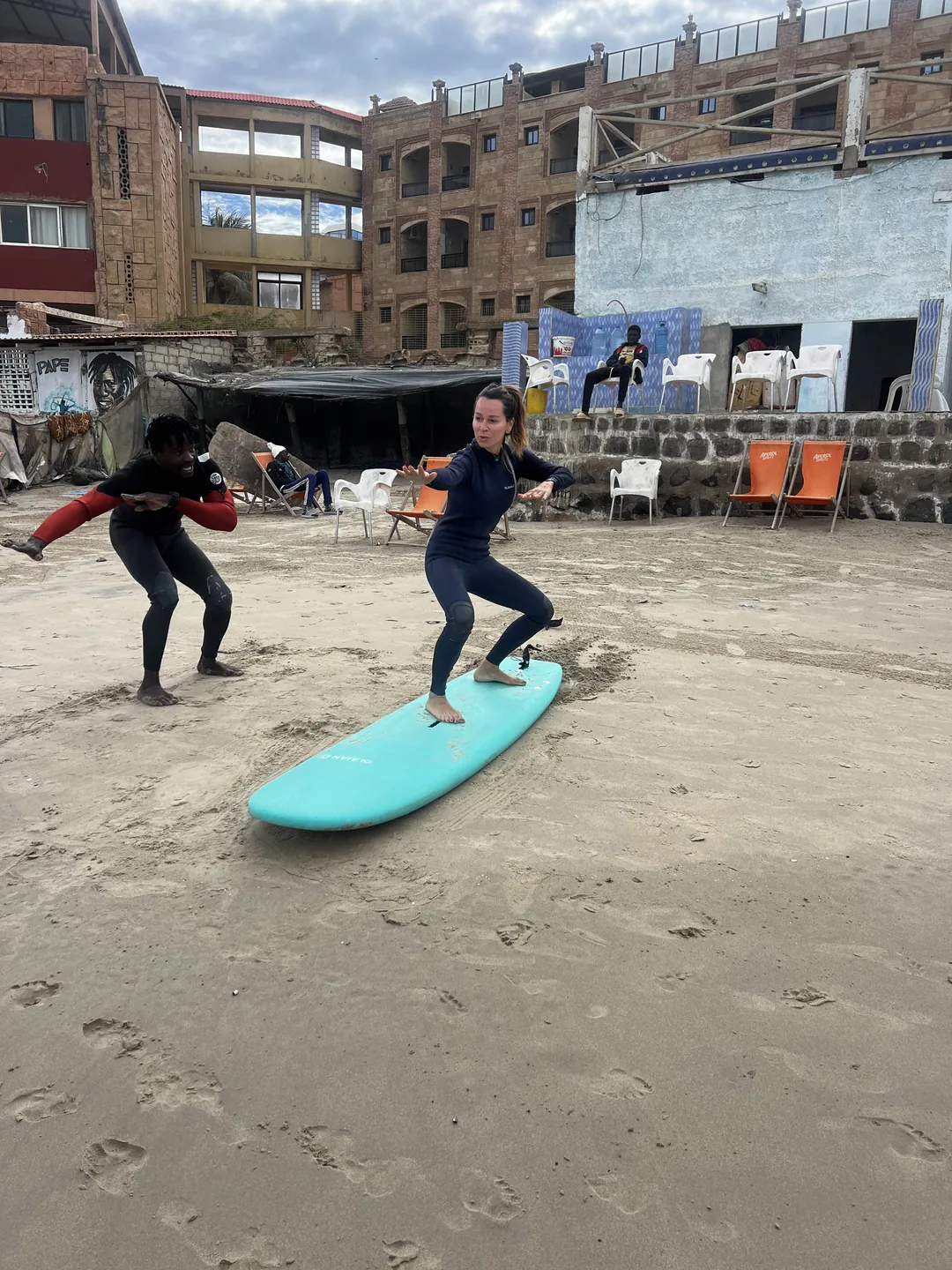 Une surfeuse apprend à naviguer sur sa planche au surfcamp de Ngor au Sénégal.