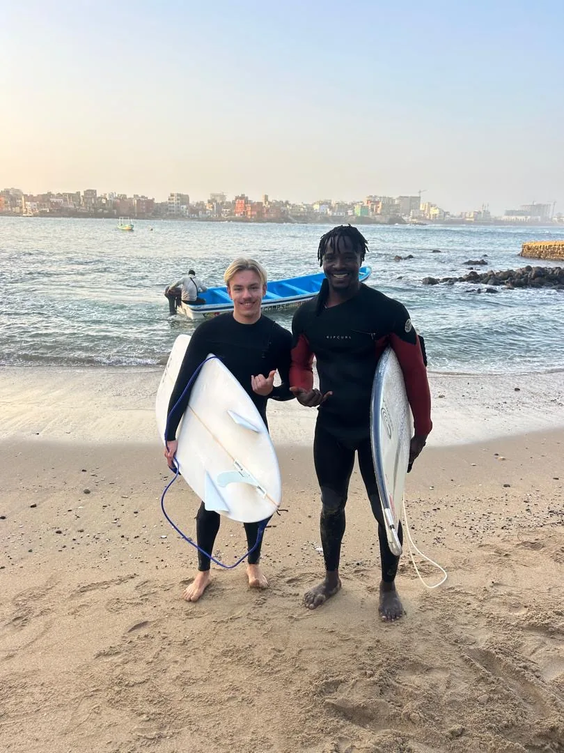 Deux surfeurs posent sur la plage de l'île de Ngor au Sénégal.