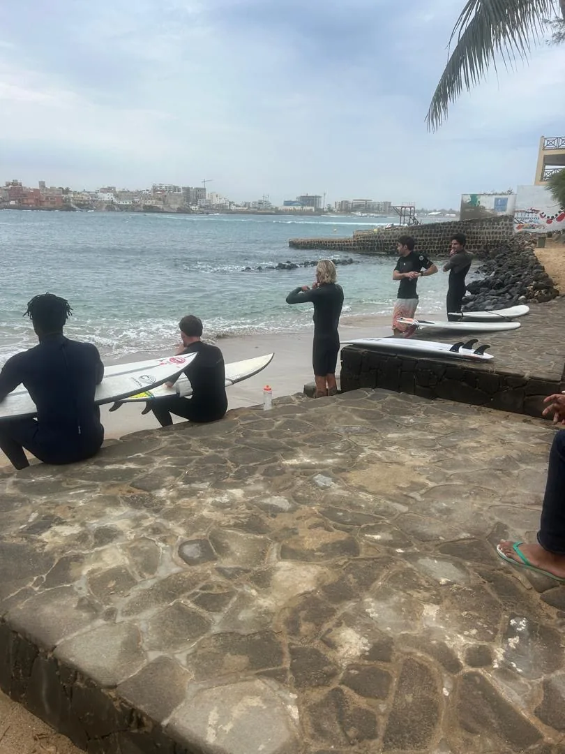 Un groupe de surfeurs se prépare sur la plage de l'île de Ngor.