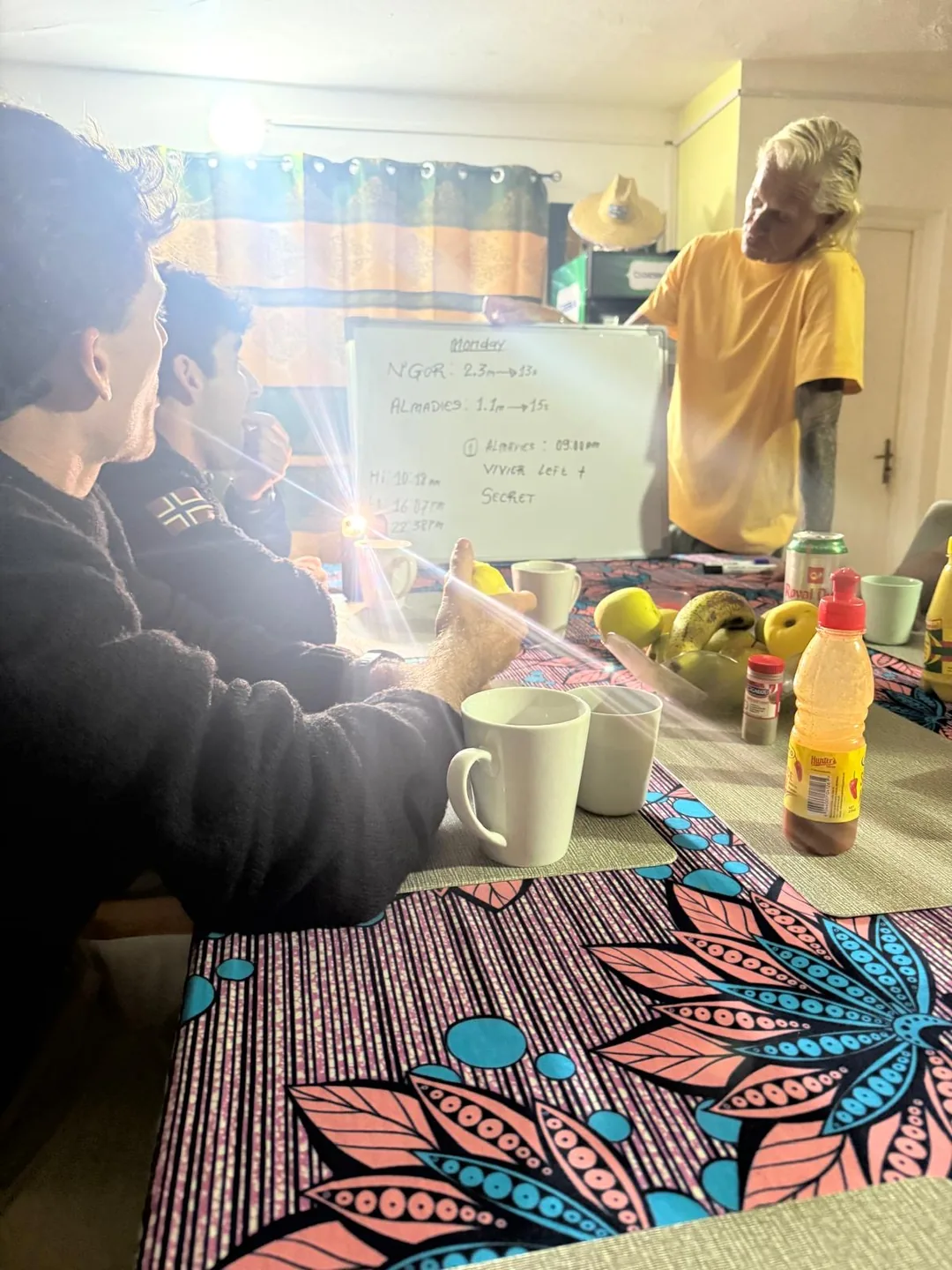 Un groupe discute des cours de surf au surfcamp de l'île de Ngor.