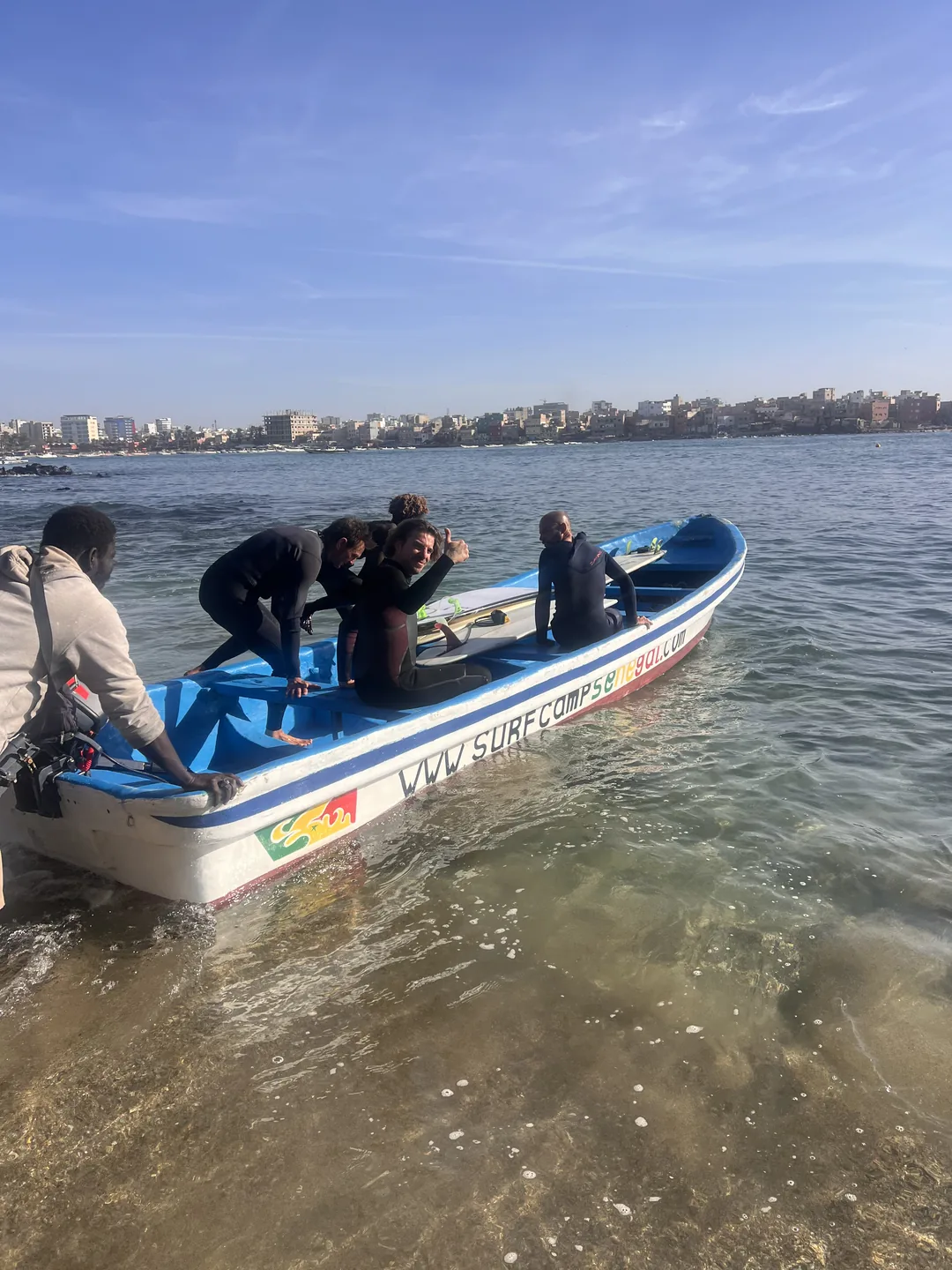 Un groupe de surfeurs se prépare sur un bateau à l'île de Ngor au Sénégal.
