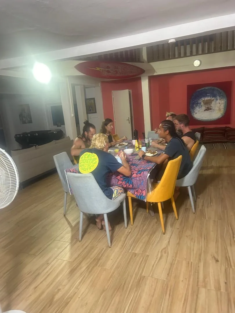 Un groupe partage un repas convivial au surfcamp de l'île de Ngor.