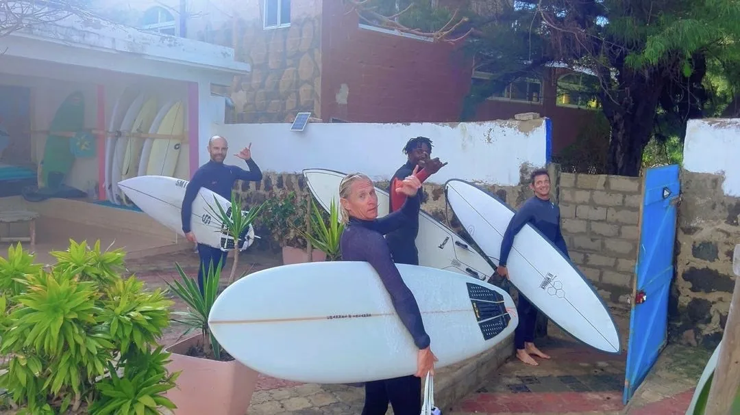 Un groupe de surfeurs prêts à conquérir les vagues à Ngor, Dakar.