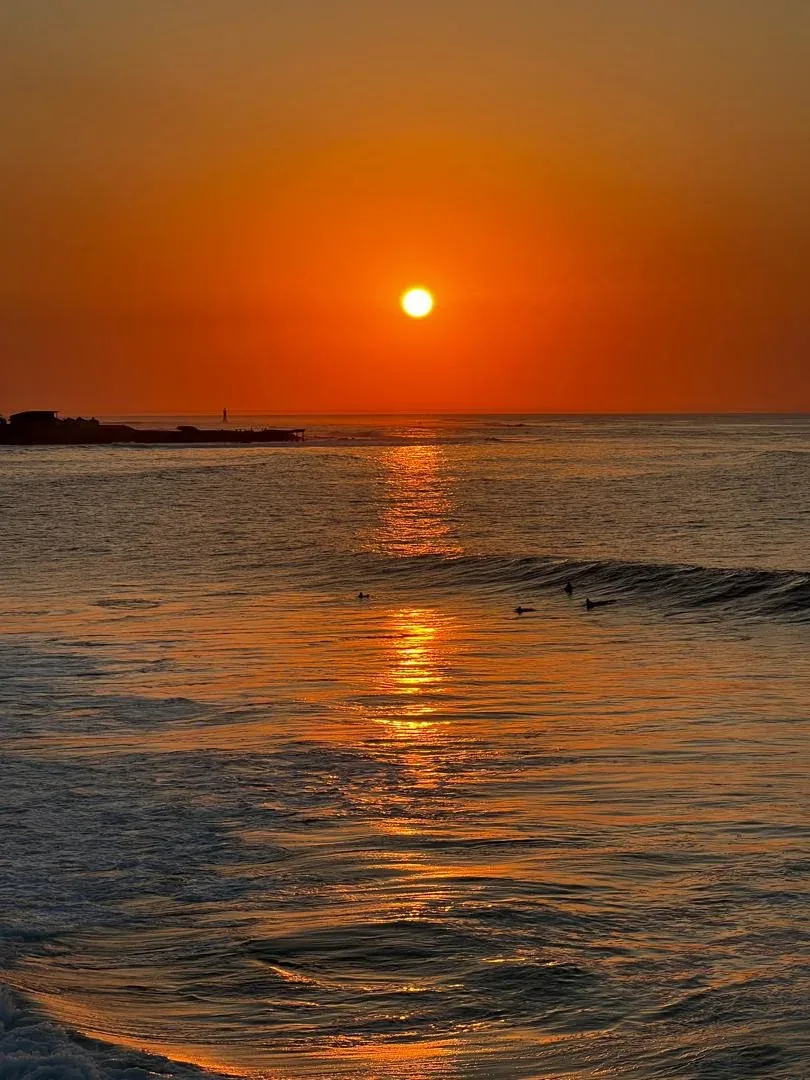 Sunset over calm ocean waves.