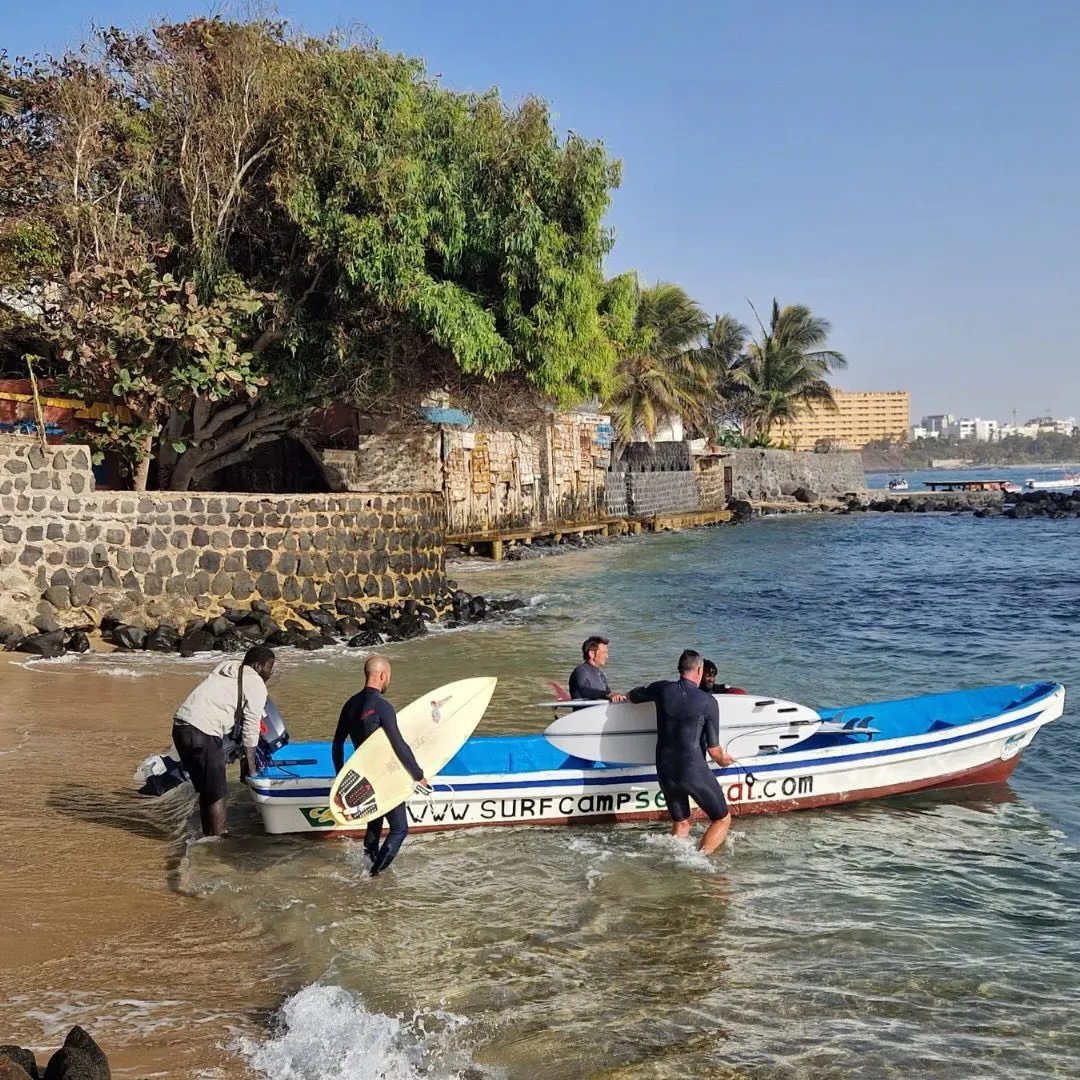 Surfers entering the water at Ngor Island