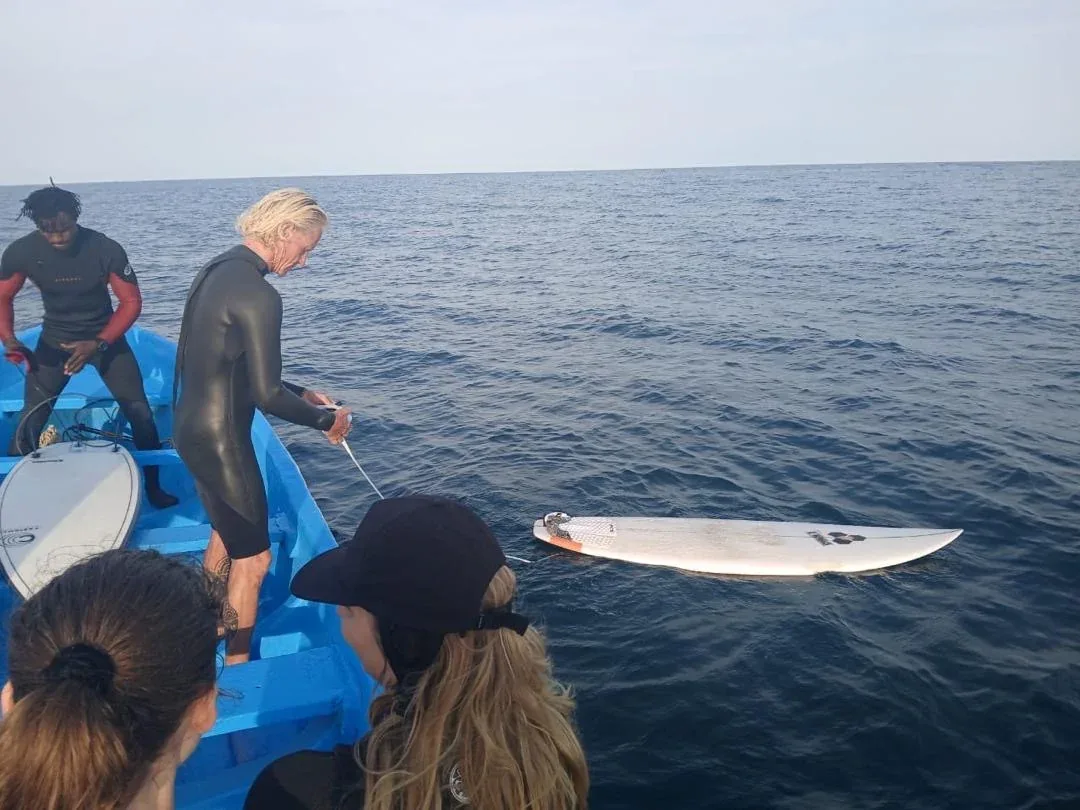 Surfers prepare for a session off Ngor Island.