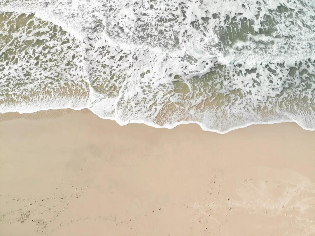 Une vue aérienne des vagues et du sable sur l'île de Ngor au Sénégal.