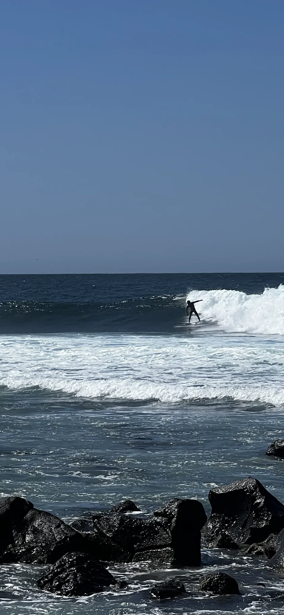 Surfer riding a wave at Ngor Island.