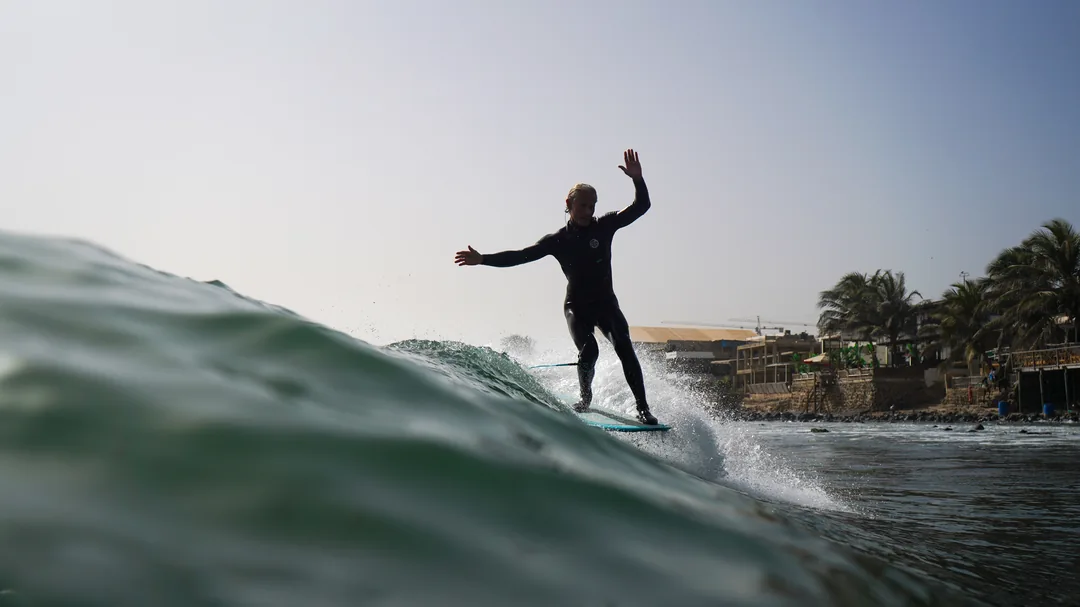 Un surfeur évolue sur une belle vague au Sénégal à l'île de Ngor.