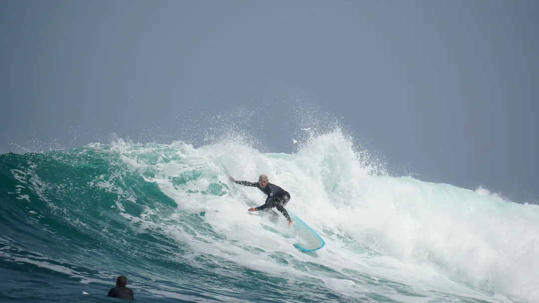 Un surfeur prend une vague sur l'île de Ngor au Sénégal.