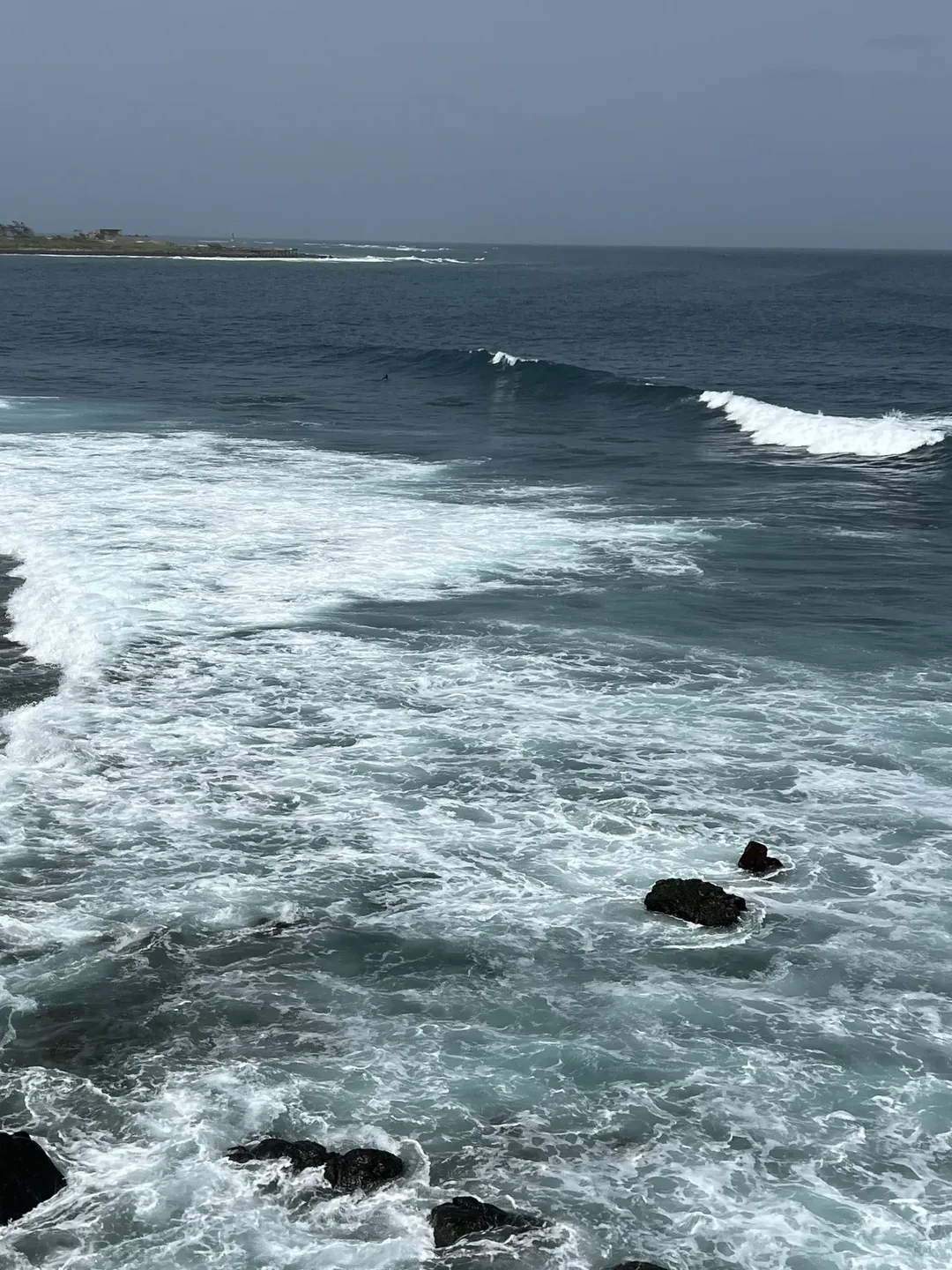 Waves crashing against rocky shoreline.