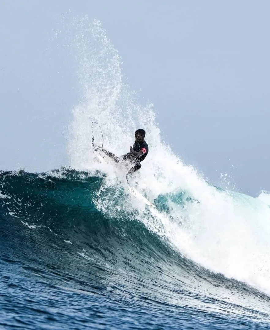 Un surfeur manœuvre avec aisance sur une belle vague au Sénégal.