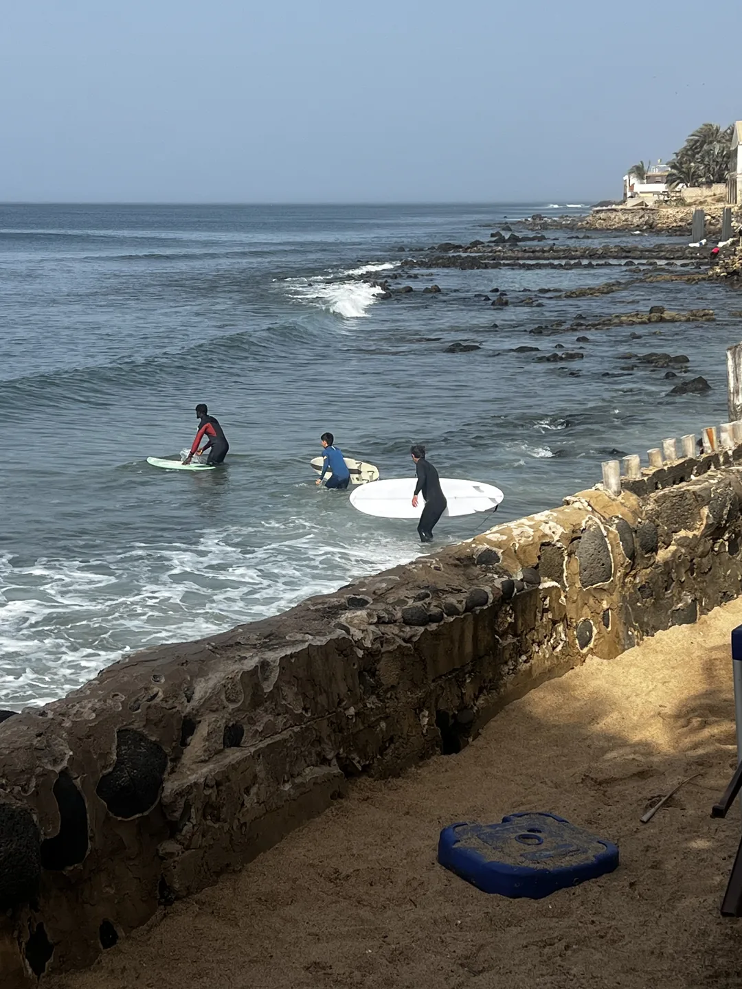 Un surfcamp animé sur l'île de Ngor avec des surfeurs prêts à prendre les vagues.