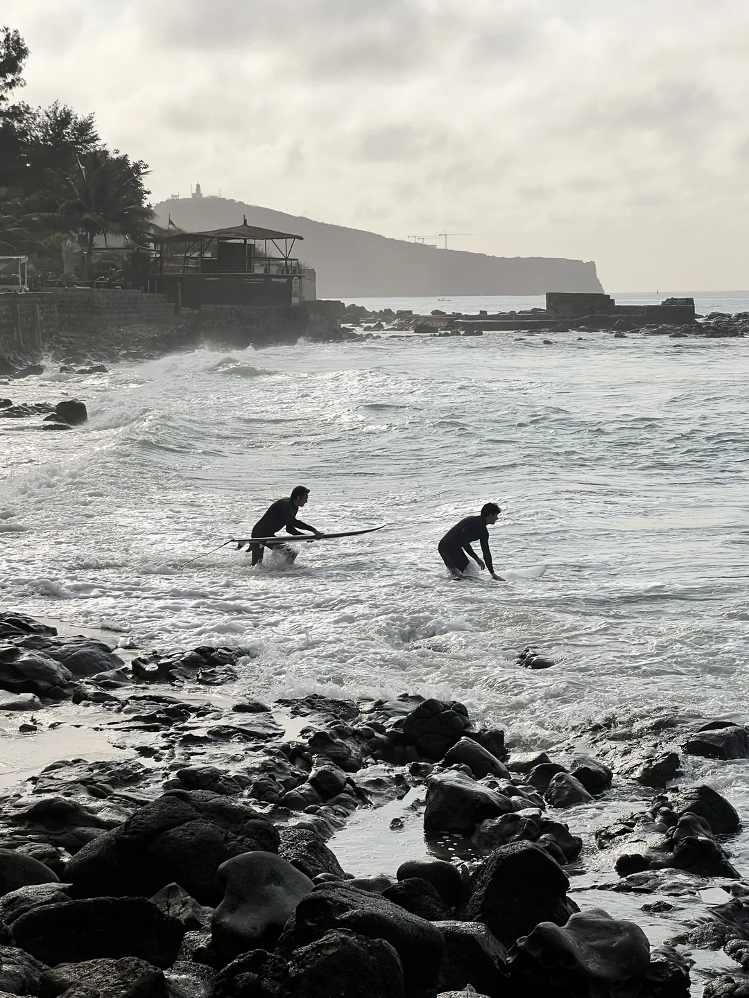 Deux surfeurs se préparent à attraper des vagues sur l'île de Ngor au Sénégal.