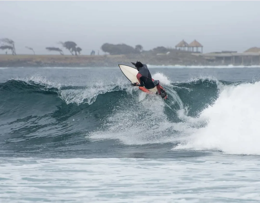 Surfeur réalisant un trick sur une belle vague au Sénégal.