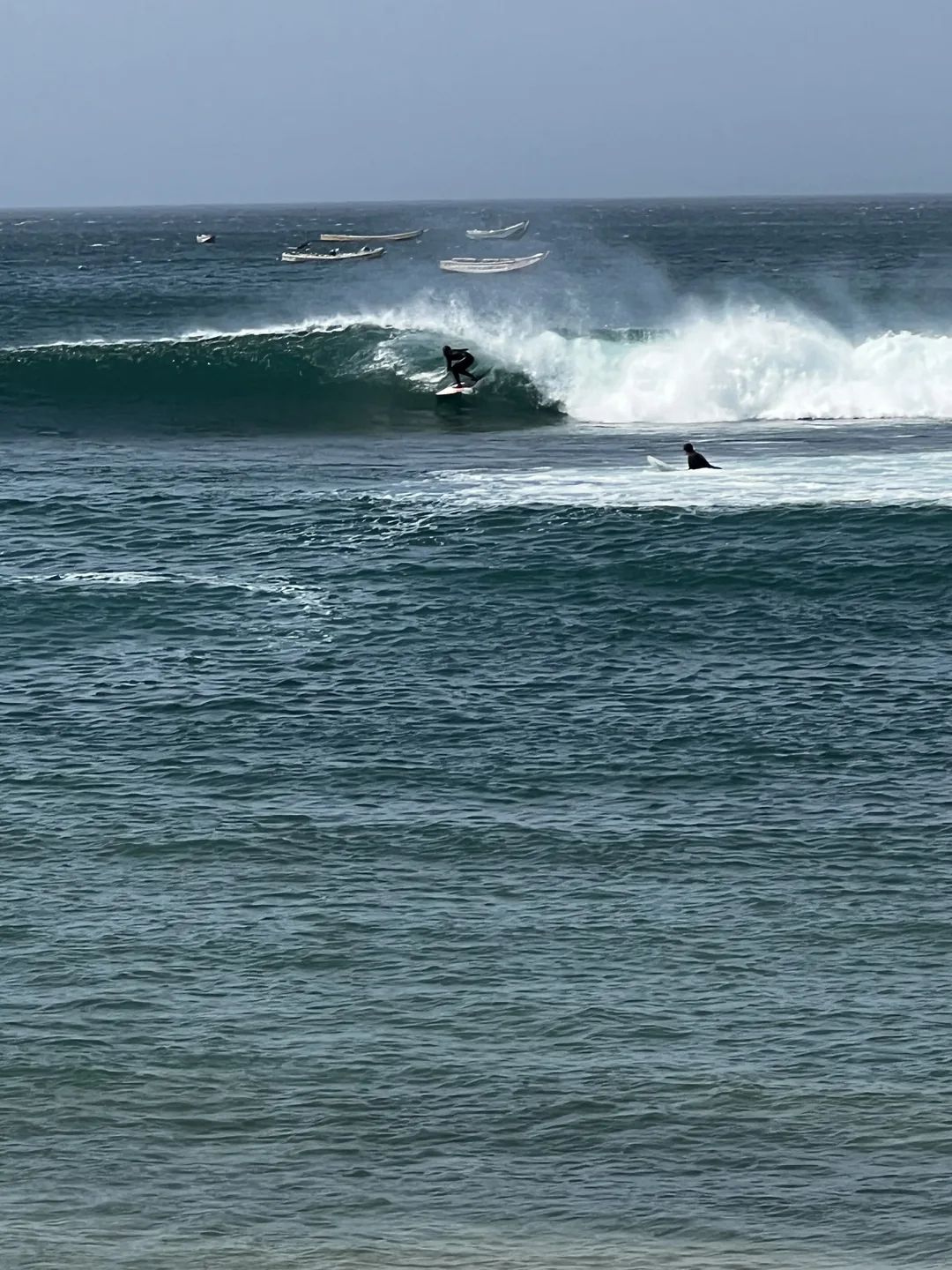 Un surfeur prend une vague sur l'île de Ngor, un lieu idéal pour le surf.