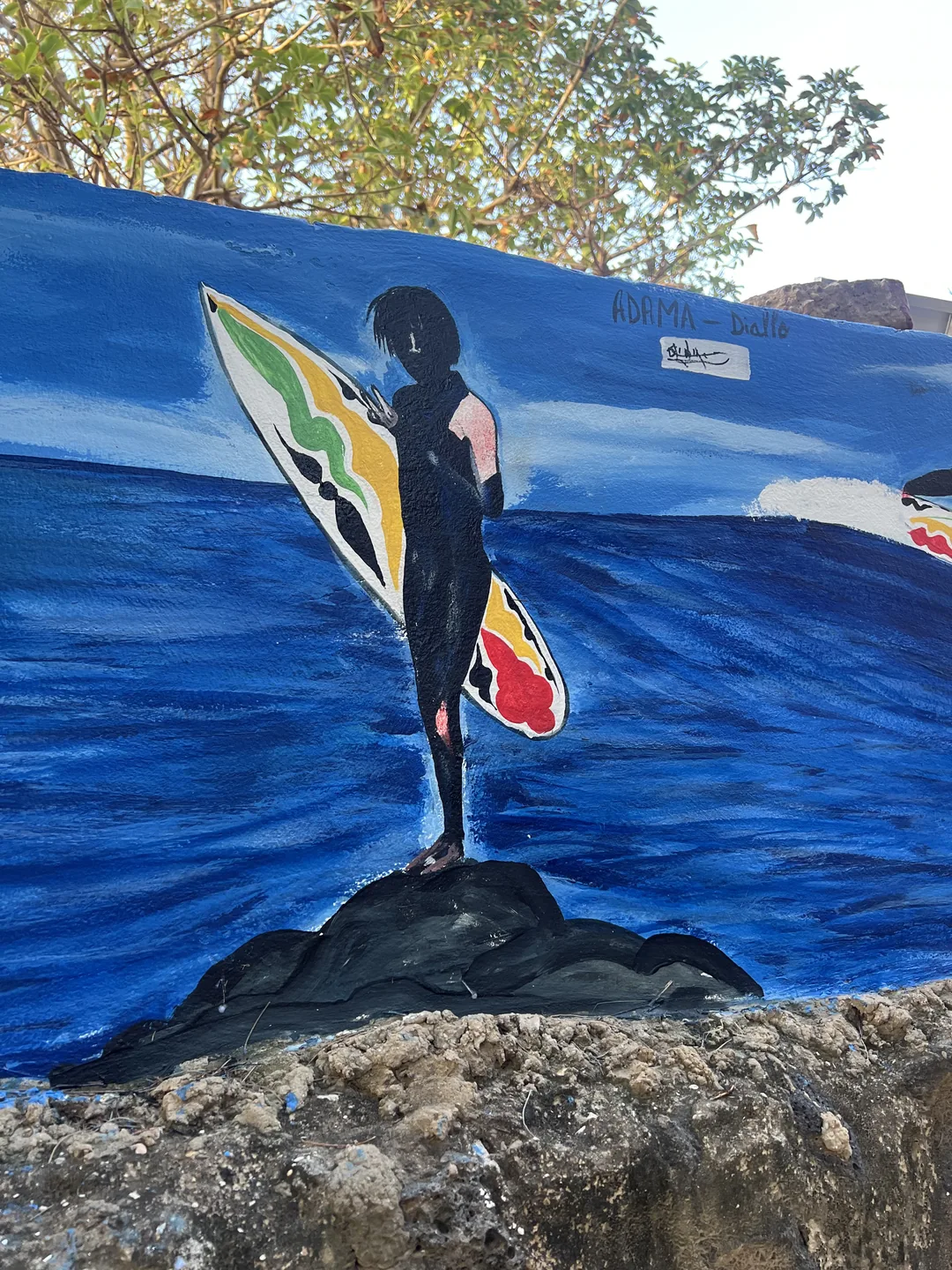 Une fresque artistique inspirée du surf au Sénégal, représentant un surfeur sur l'eau.